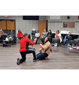 Community members learning a self-defense technique together